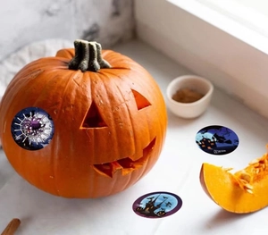 Detail von Halloween Aufklebern mit Hexe und Kürbis Designs auf einem echten Kürbis