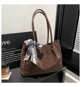 Détail du cabas mat marron foncé avec élégant foulard en soie sur la poignée