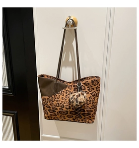 Detail der großen Leopard-Tote-Bag am Holzhaken mit Herzanhänger für Damen
