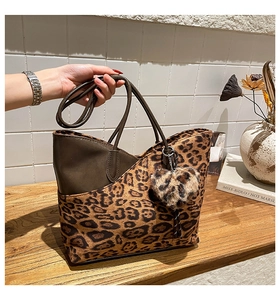 Detail einer Leopard-Tote-Bag mit Plüsch-Herzanhänger und braunem Randdekor