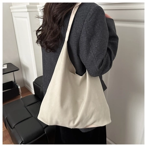 Rear view of model wearing a large cream canvas tote bag for daily commute and casual style