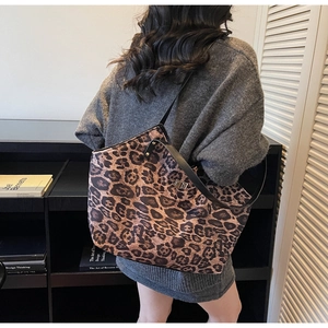 Close-up of leopard print tote bag with black strap and silver twist-lock closure