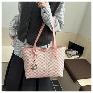 Close-up of pink tote bag with M-letter jacquard pattern and golden logo pendant