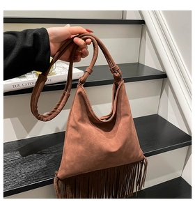 Gros plan du sac en daim marron avec de longues franges et une poignée à nœud élégante