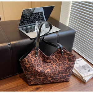 Close-up of leopard print tote bag with gold hardware and secure swivel lock closure