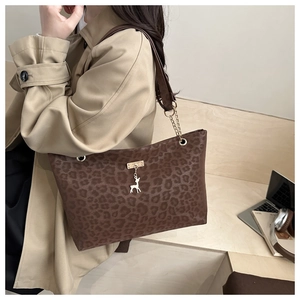 Détail du sac cabas léopard avec pendentif cerf doré et bandoulière en chaîne élégante