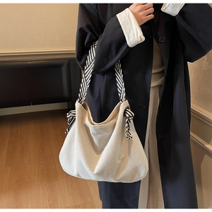 Dettaglio della borsa tote in velluto a coste bianco con texture rigata e tracolla