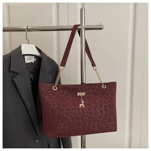 Détail du sac cabas bordeaux à imprimé léopard avec pendentif cerf et bandoulière