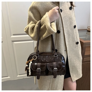 Detail of vintage brown patent leather shoulder bag with buckle pockets and wood beads