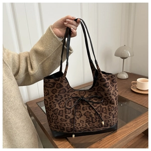 Detail einer Leopard-Print-Tragetasche mit schwarzer Schleife und großem Innenraum