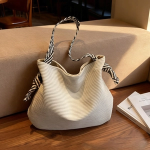 Oatmeal corduroy tote bag with zebra print knotted strap on a cozy minimalist sofa
