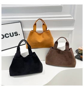 Minimalist felt bucket bags in black, yellow, and brown on a white display stand
