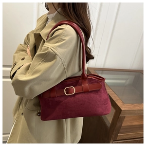 Détail du sac bandoulière en daim bordeaux avec boucle dorée et lanière en cuir