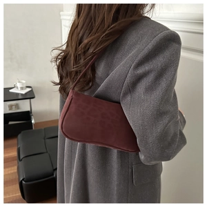 Détail du sac sous l'aisselle à motif léopard bordeaux avec texture mate lisse