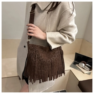 Detail of vintage brown tassel tote bag with leopard print and suede texture on model