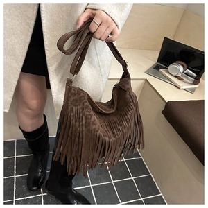Detail of a brown leopard print tote bag featuring long fringes in a cozy lifestyle setting