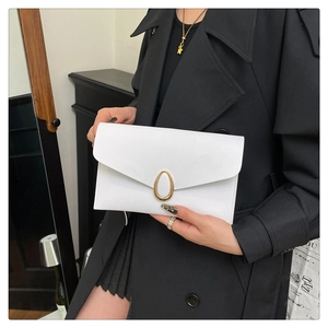Detail of white envelope clutch with litchi texture and golden oval metal buckle
