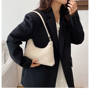 Model wearing a fuzzy white fleece crescent hobo bag with a soft plush texture