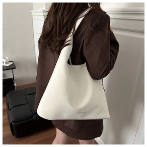Détail du grand sac cabas blanc avec logo FASHION porté par un mannequin en blazer