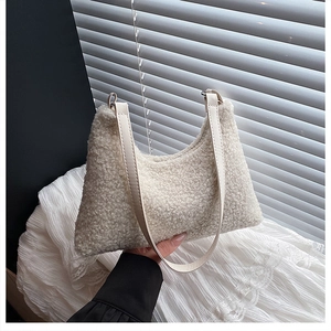 Dettaglio della borsa tote in peluche bianca con manico in pelle PU crema liscio