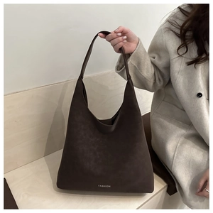 Détail du grand sac cabas en daim marron foncé avec lettrage Fashion et fini mat