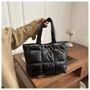 Vue détaillée du sac cabas matelassé noir avec poignées larges et boucle ronde