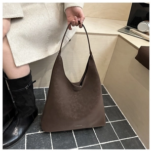 Dettaglio della borsa tote marrone scuro opaca con scritta FASHION in pelle martellata