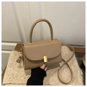 Detail of khaki square crossbody bag featuring gold buckle and round rigid handle