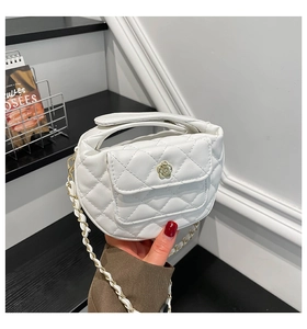 Detail of white quilted PU leather handbag with camellia buckle and chain strap