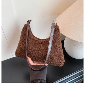 Close-up of brown fuzzy fleece tote bag texture with smooth dark brown shoulder strap
