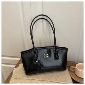 Detail showing the gold metal buckle and HIOC 2DN lettering on black glossy tote bag