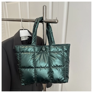 Détail d'un sac cabas matelassé vert foncé fini métallique avec coutures carrées