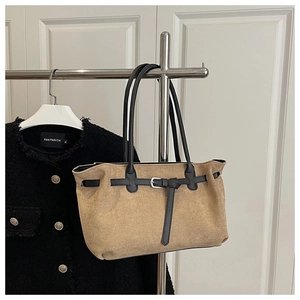 Detail of khaki faux suede tote bag with black leather straps and silver buckle detail