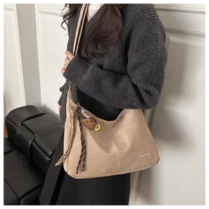 Detailed side view of khaki shoulder bag with bow charm and Tidal Breeze lettering