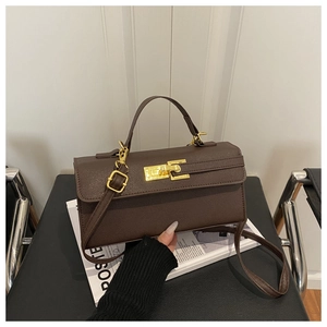 Détail du sac bandoulière marron avec fermoir tournant doré et texture cuir élégante