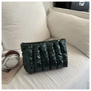 Detail der dunkelgrünen gesteppten Kosmetiktasche mit Hochglanz-Finish und Goldreißverschluss