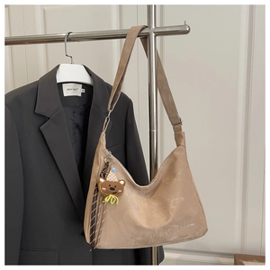 Detail of khaki suede Hobo bag with adjustable strap and cute bear charm accessory