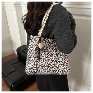 Detail of leopard print tote bag with woven handles and ice cream pendant accessory