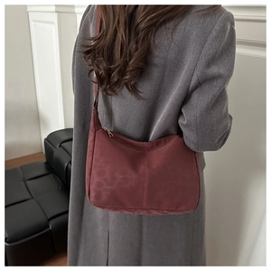 Detail of burgundy leopard jacquard tote bag on shoulder with minimalist metal zipper