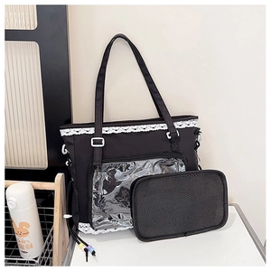 Detail view of black canvas tote bag with transparent PVC pocket and white lace trim