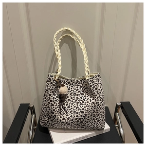 Detalle de bolso leopardo con asas trenzadas y colgante de helado de felpa en una silla