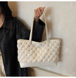 Detail of plush beige tote bag showing honeycomb texture and durable leather base
