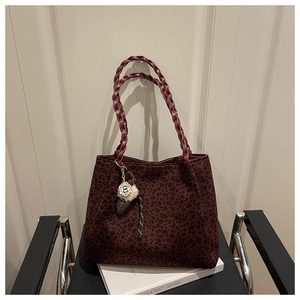 Detalle de bolso tote con estampado de leopardo rojo oscuro y asa trenzada gruesa