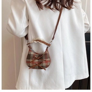 Detalle del bolso bandolera vintage de cuadros con lazos de cuero y encaje suave