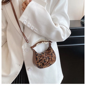 Detalle de mini bolso de leopardo con lazos de cuero y ribetes de encaje blanco elegante