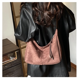 Back view of model wearing a retro dark pink suede tote bag with fringe detail