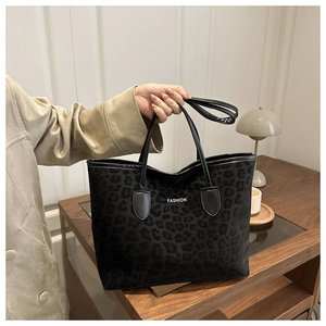 Detail van zwarte tote bag met luipaardprint, FASHION-tekst en lederen handvat