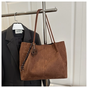 Detailed view of brown matte tote bag featuring stylish side braided rope and metal ring charm