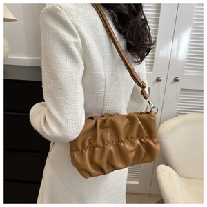 Sac nuage plissé caramel porté avec un blazer blanc en tweed pour un style moderne