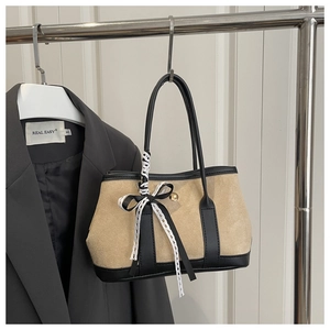 Detail of leopard print bucket bag with suede texture and decorative lace bow